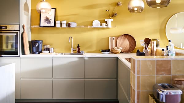 A kitchen with UPPLÖV fronts in dark beige, an ANRÄTTA forced air oven with pyro function in stainless steel and other items.