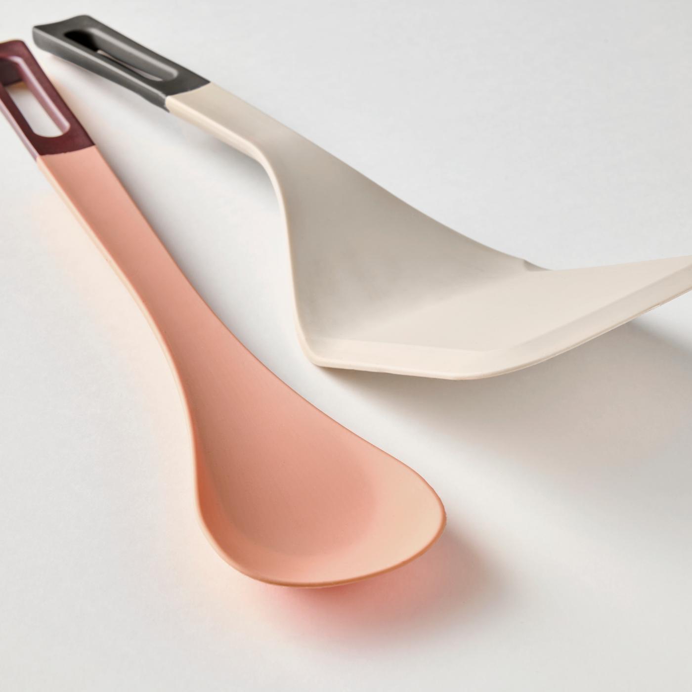 A KNORRHANE spatula and a spoon for cooking, in different colours, on a white surface.