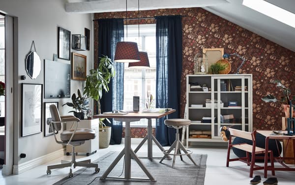 À la fois fonctionnels et modernes, le bureau assis/debout, le caisson à tiroirs et la vitrine beiges IKEA IDÅSEN apportent un équilibre au bureau à domicile.