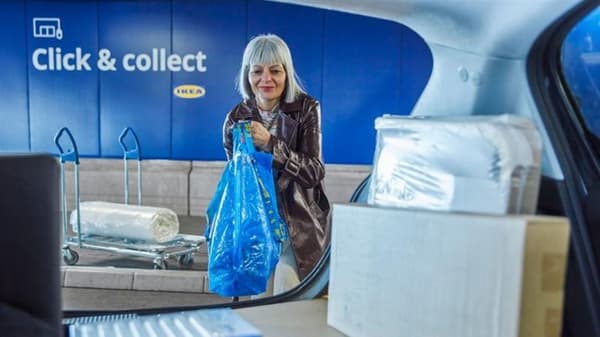 A lady loading IKEA flat pack brown into the car in the IKEA parking garage