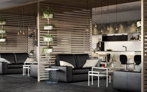 A large airy business office space with IKEA KIVIK black leather sofas and slatted wood room dividers.