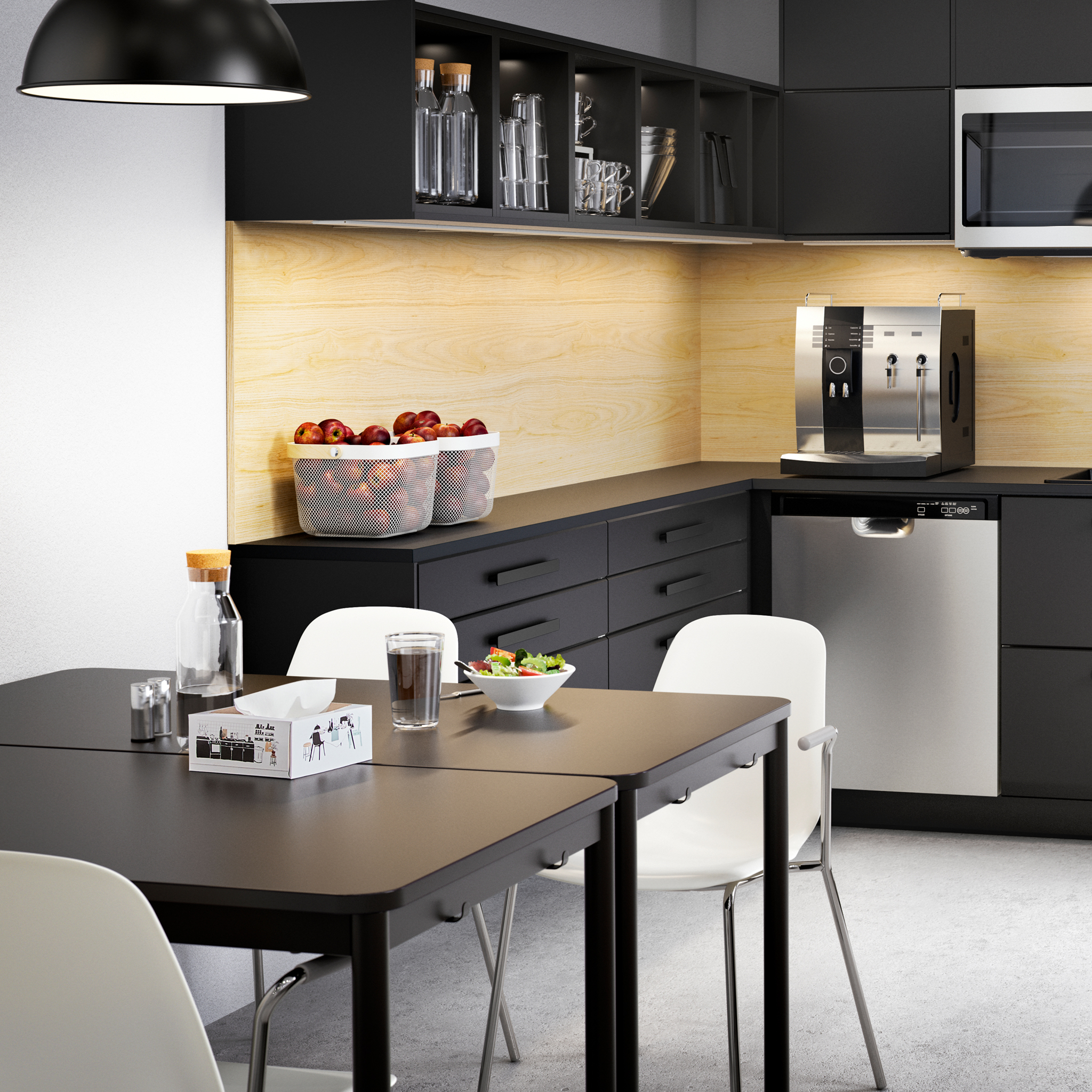 A large anthracite kitchen with drawers and cabinets, coffee machine, bowls with fruits and two tables with white chairs.