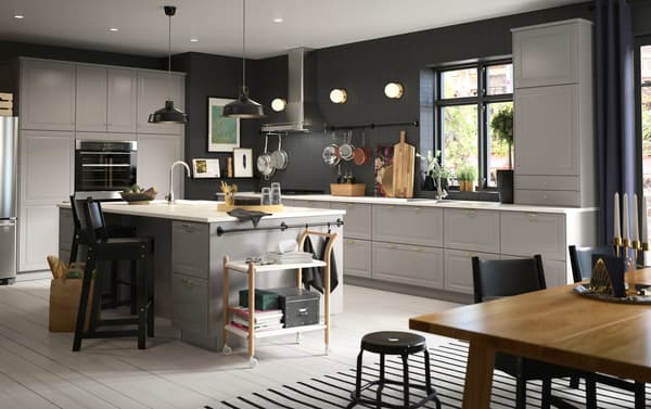 A large grey and black kitchen with an island in the centre.