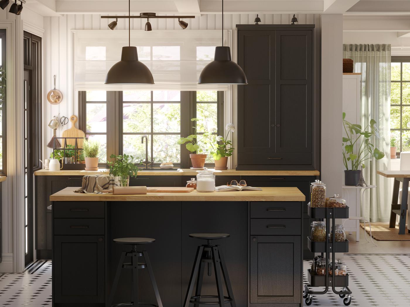 A large LERHYTTAN kitchen with black-stained fronts and a kitchen island in the center with two black pendant lamps above it.
