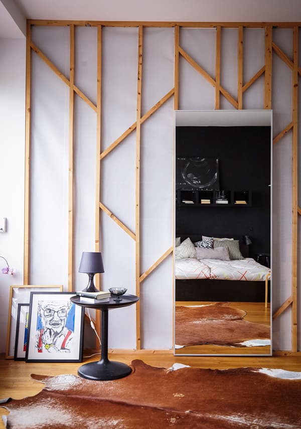 A large mirror leaning on a wall in a bedroom.