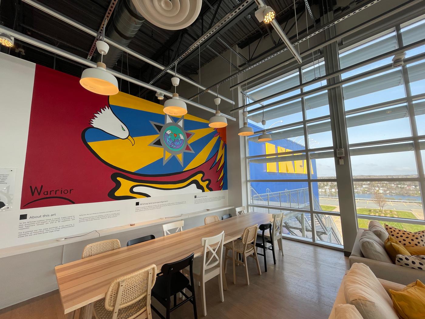 A large wall mural is showcased in a brightly lit building.