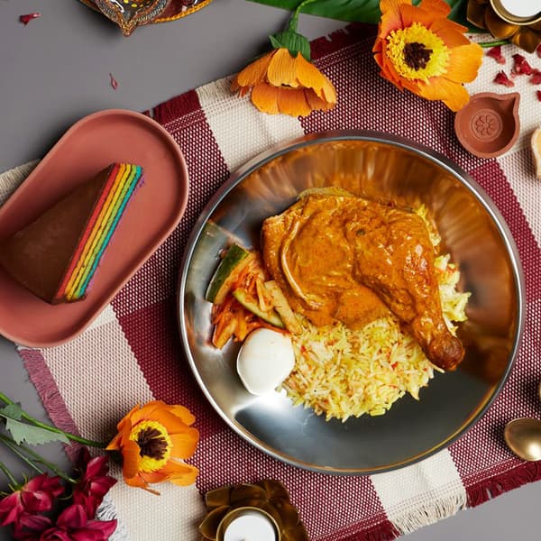 A lifestlye shot of IKEA Swedish Restaurant's upcoming Deepavali Special, featuring Chicken curry briyani set with rainbow cake and a free refill cold drink. 