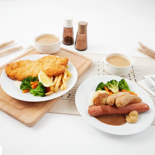 A lifestlye shot of October Feast Special happening at IKEA Singapore - Banger & mashed (2 pcs of German Pork Bratwurst & 1 pc Smoked Chicken Garlic Bratwurst with mashed potato, cream sauce & mild mustard) and Pork Schnitzel with fries & aioli sauce 