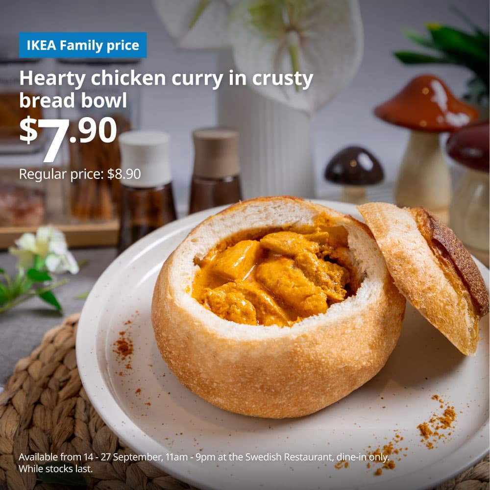 A lifestyle image of the hearty chicken curry in crusty bread bowl with white text overlaying image on the top left that reads 'Hearty chicken curry in crusty bread bowl, $7.90, Regular price: $8.90'. Followed by the fine print text in white on the bottom left that reads 'Available from 14 - 27 September, 11am - 9pm at the Swedish Restaurant, dine-in only. While stocks last.'.