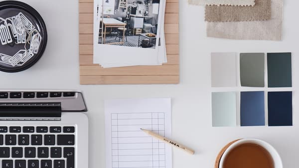 A light desktop with scattered but symmetrically arranged office accessories and desk-work paraphernalia.