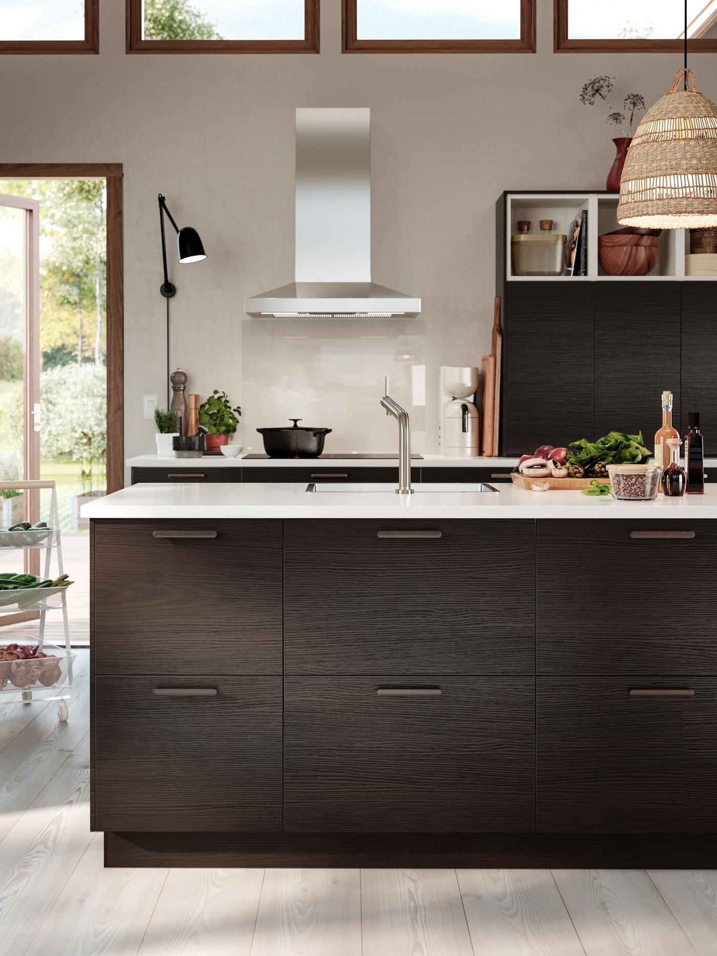 A light drenched and retro inspired ASKERSUND kitchen in dark brown ash effect with a VINSTGIVANDE extractor hood.