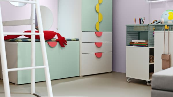 A light green and white SMÅSTAD storage combination in a children's room.