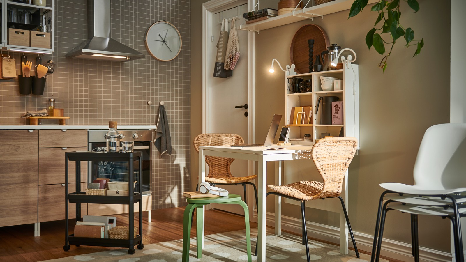A light kitchen with ÄLVSTA rattan-seat-and-black-frame chairs and other seating at a white MELLTORP table.