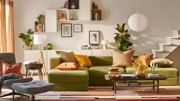 A light living room centred around a JÄTTEBO three-and-a-half-seat sofa with chaise longue and EKET wall-mounted cabinets.