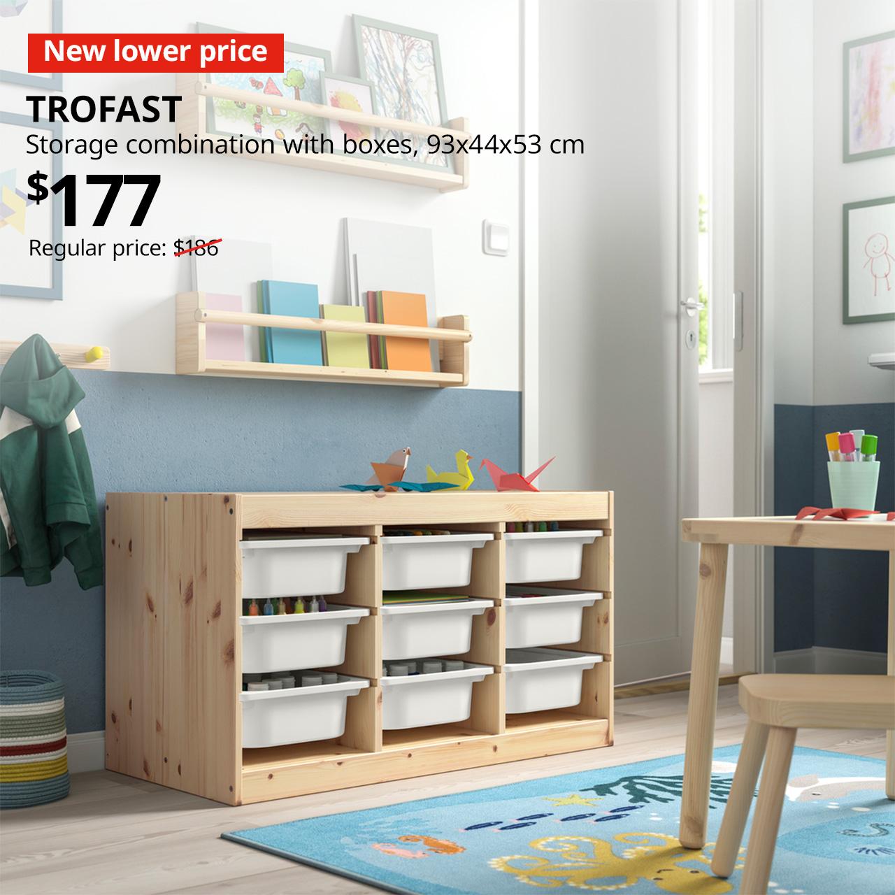 A light white stained pine with white storage boxes TROFAST storage combination in a children's room setting. A red tag with white text that reads "New lower price", followed by black text overlay image that reads, "TROFAST, Storage combination with boxes, 93x44x53cm, $177, Regular price: $186".