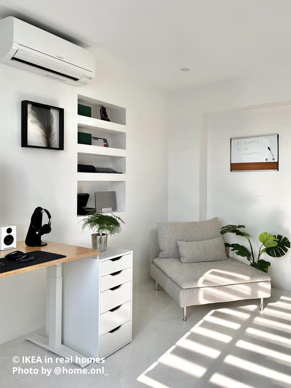 A light wood sit/stand desk similar in style to the MITTZON desk, with a white ALEX drawer unit beside it. A beige/brown SÖDERHAMN sofa with a VIARP cover is placed in the corner, creating a comfortable home office corner. Photo by instagrammer @home.onl_ from IKEA in real homes ©