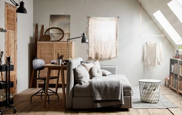 A living area with lounge seating, desk and chair and cabinets