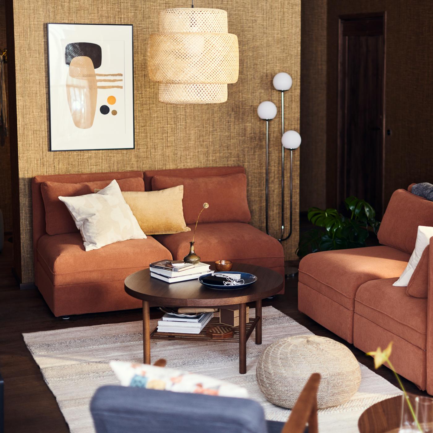 A living room corner with sofas, a lamp and a hanging lamp shade and a coffee table.