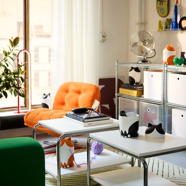 A living room displaying several cat-shaped GREJSIMOJS storage boxes 
