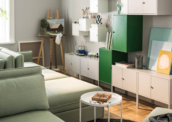 A living room is styled with modular sofas and lots of wall storage.