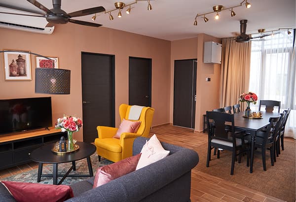 A living room setting featuring a yellow wing chair, sofa and dining area.