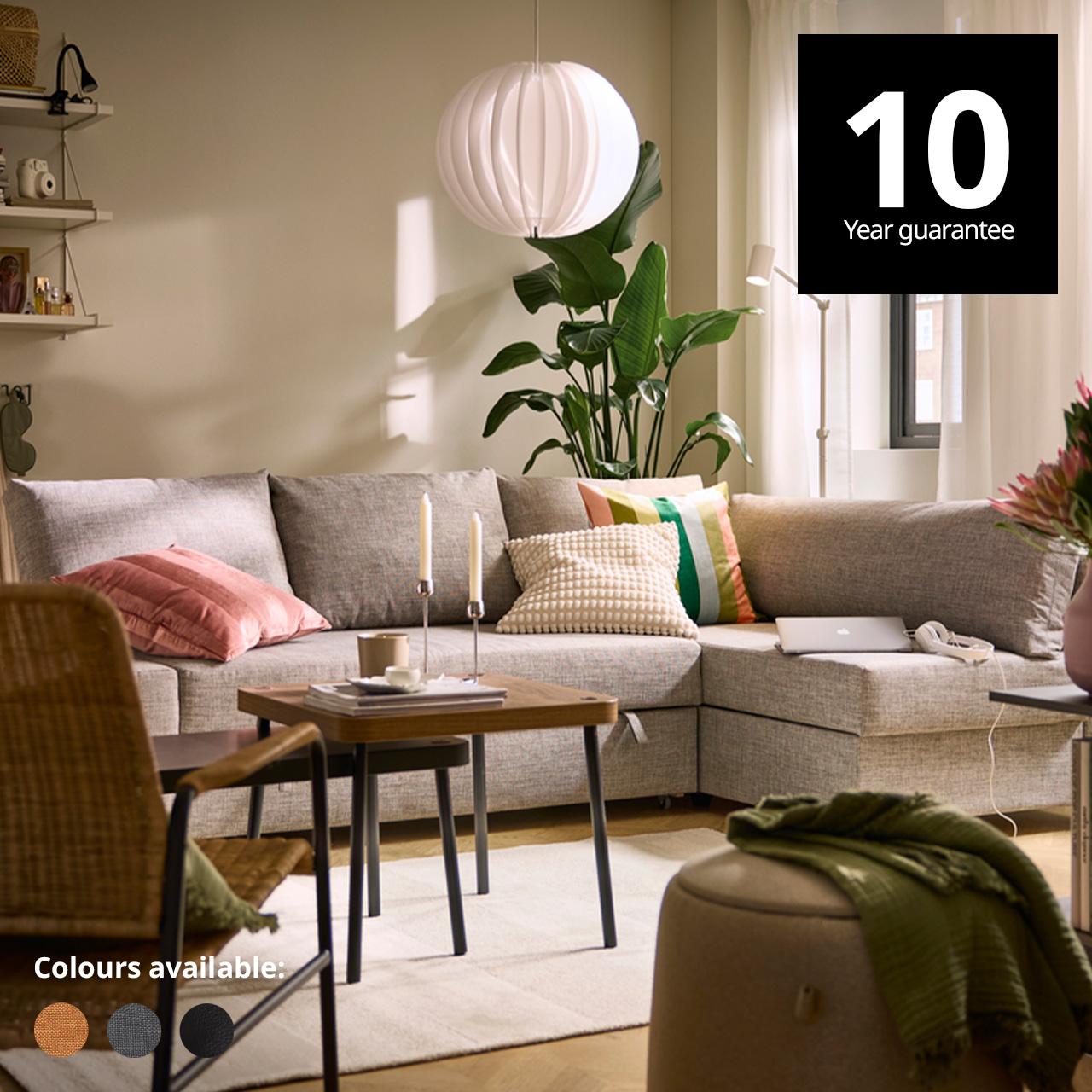 A living room setting with a FRIHETEN corner sofa-bed with storage in faringe light grey. A 10-year guarantee tag is placed over the image at the top right corner. White text overlay image that reads "Colours available:" with the colour swatch of Faringe brown-orange, Skiftebo dark grey and Bomstad black.