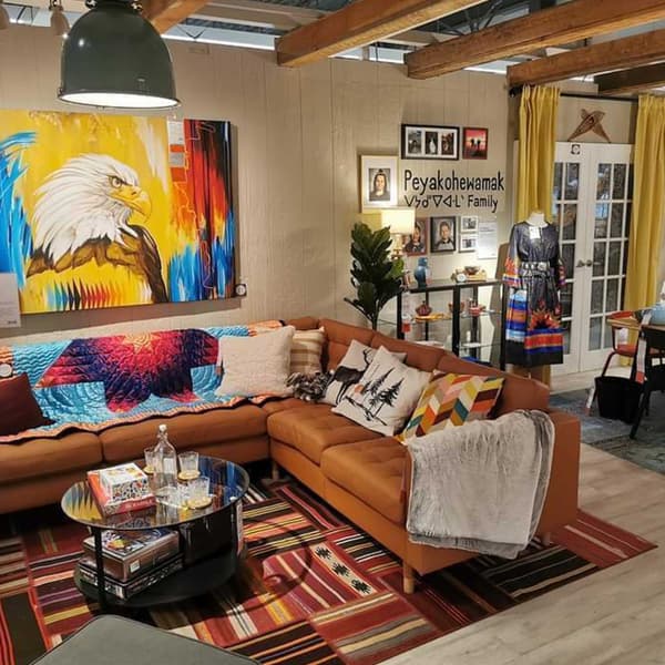 A living room space with colourful textiles and art on the wall. 