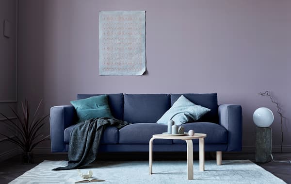 A living room updated for fall with a grey sofa, pink walls, blankets and natural elements.