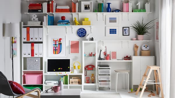 A living room with an entire wall with shelves and cabinets dedicated to book, toys, collectibles and magazine storage.