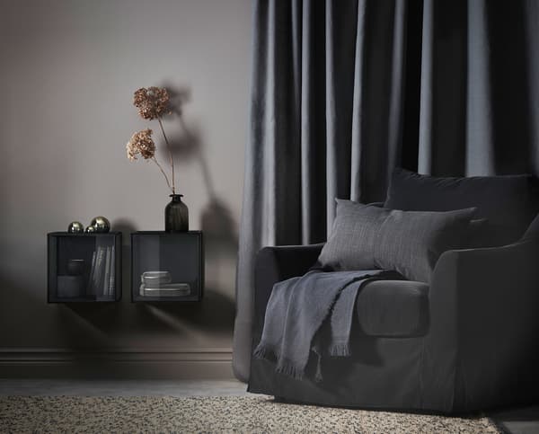 A living room with dark grey armchair and a beige rug.