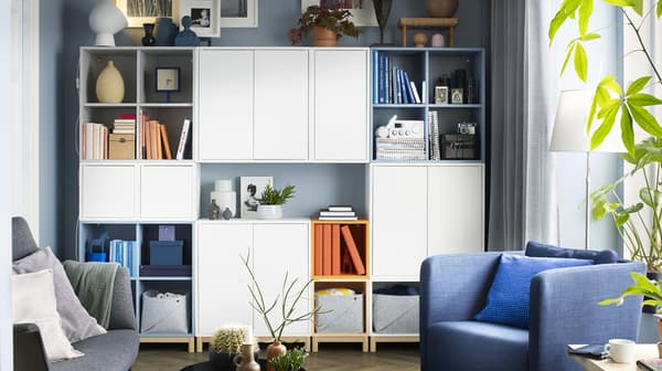 A living room with EKET wall cabinets filled with books and accessories.