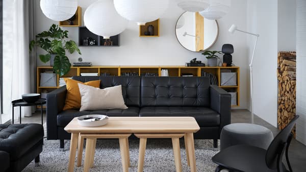 A living room with furniture such as MORABO sofa, storage cabinets, tables and lampshades.
