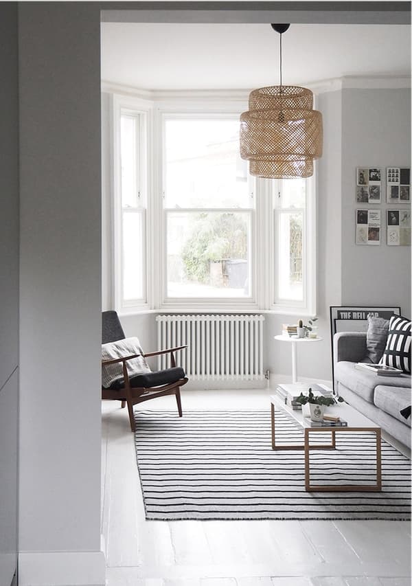 A living room with grey sofa, striped rug and relaxed armchair. 