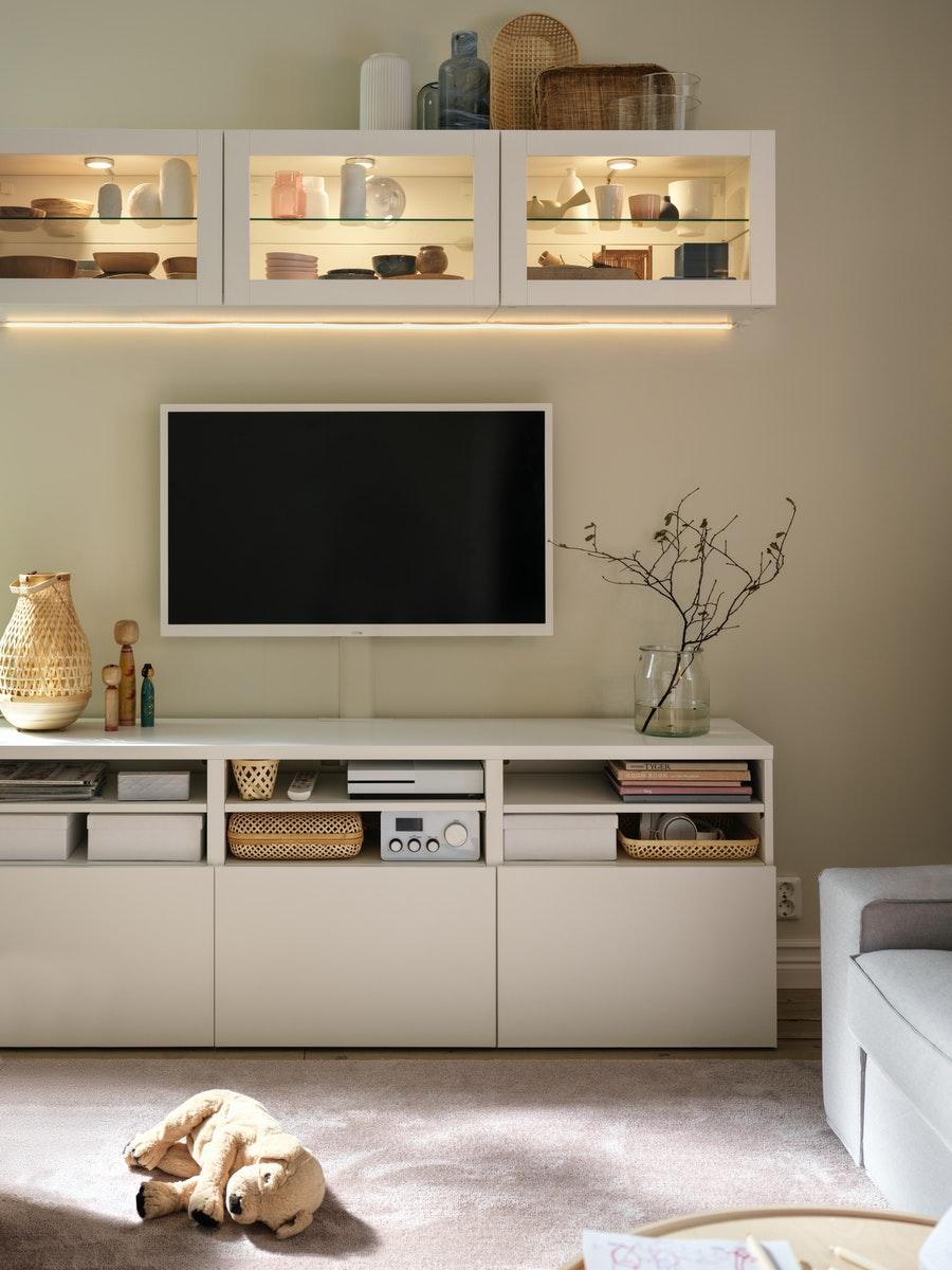 A living room with tv, media unit and couch.