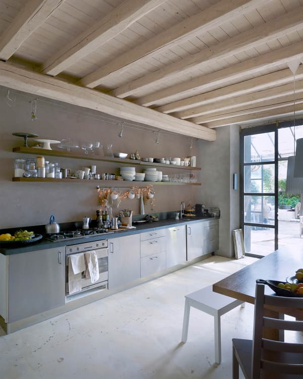 A long floating shelf displays (and stores) dishes and glassware in this kitchen.