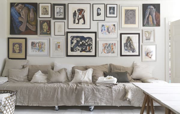 A long seating area below a gallery wall of art.