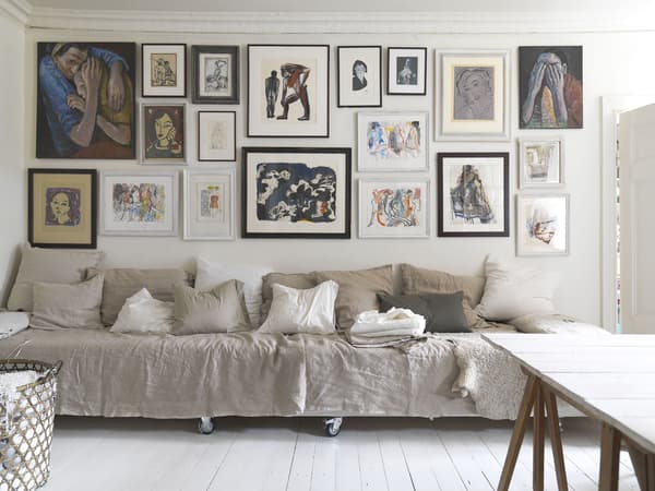 A long seating area below a gallery wall of art.