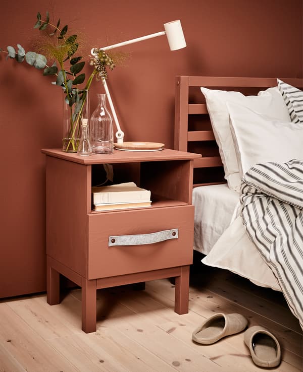 A madeover bedside table sits next to a bed.