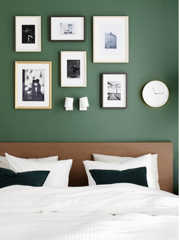 A MALM bed frame in black brown veneer, quilt cover and pillowcases in white and gold-coloured SILVERHÖJDEN frames.