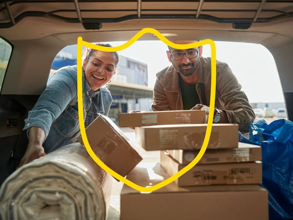 A man and a woman are packing products into the car.