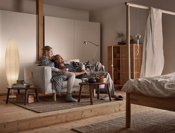A man and a woman relaxing on a sofa.