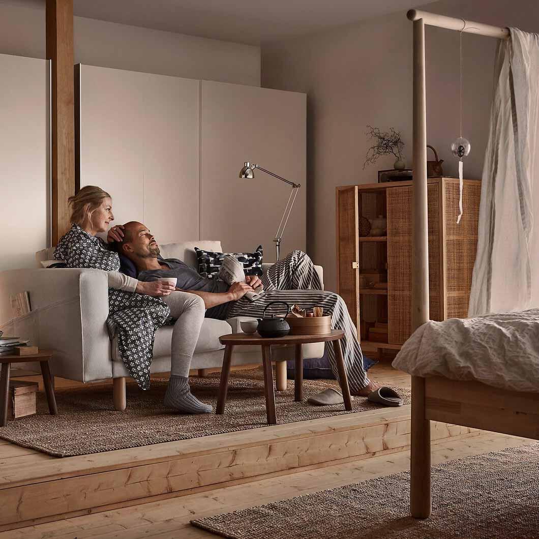 A man and a woman relaxing on a sofa.