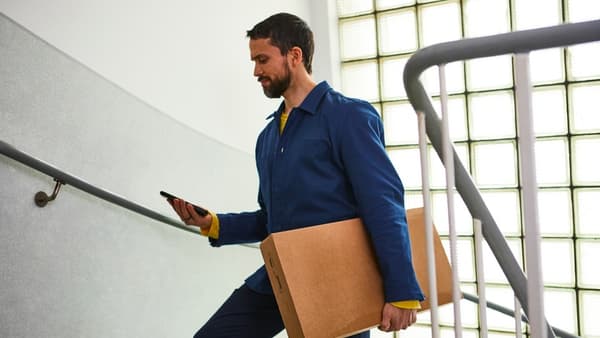 A man brings a parcel up to the customer.