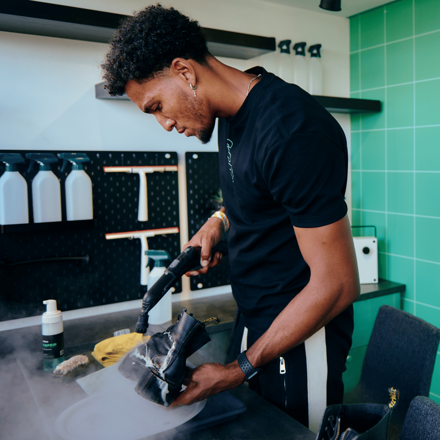 A man cleaning in a room with green walls