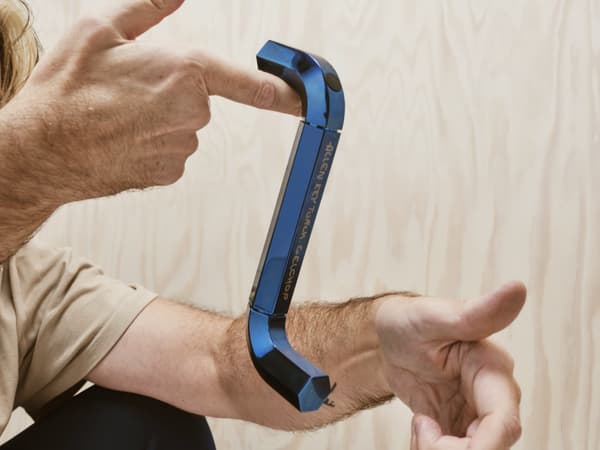 A man holding an IKEA allen key blue lamp