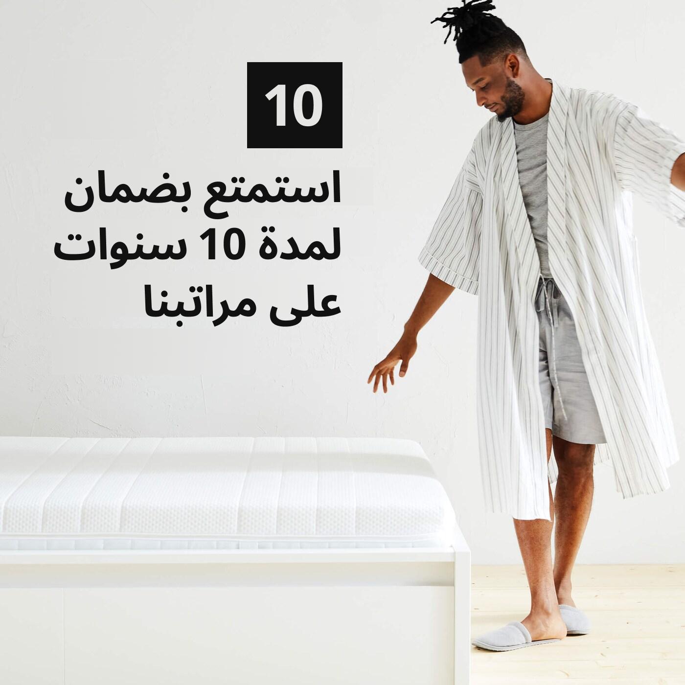 A man in a robe standing next to a mattress and a number 10 graphic symbol and the text 'Our mattresses come with a 10-year limited warranty' on the image.