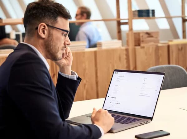 A man in a suit browsing IKEA online on his laptop.