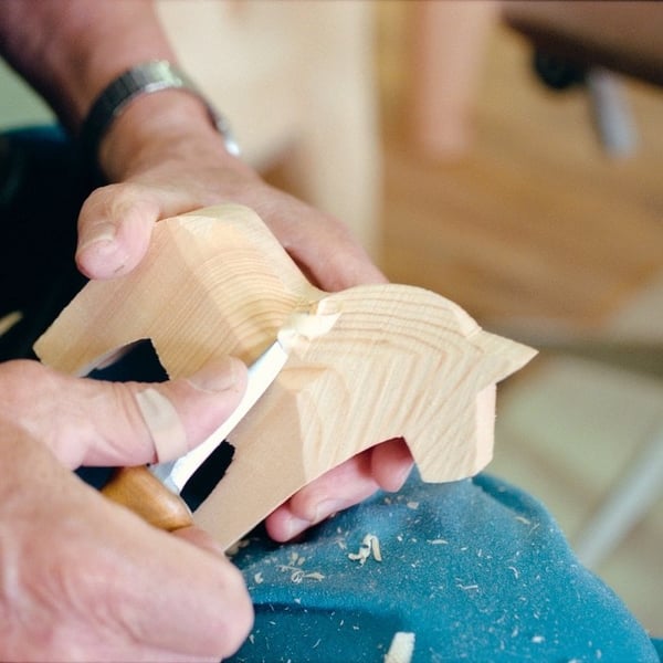 A man is carving a horse.