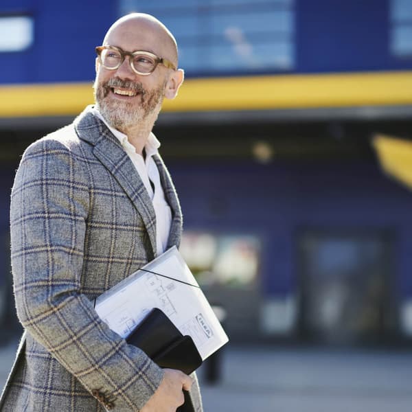 A man is smiling in front of ikea store entrance 