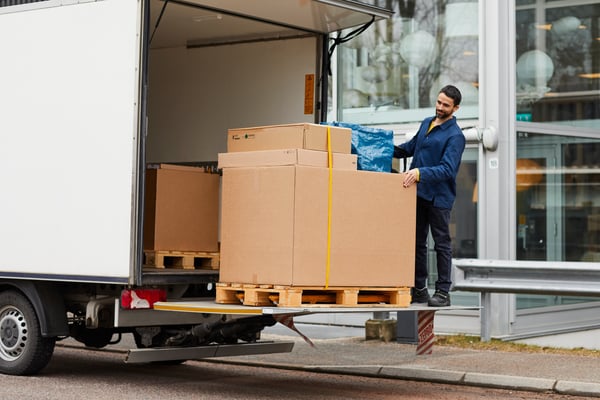 A man is unloading packages from the delivery truck.